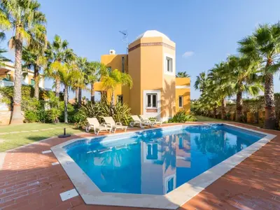 a swimming pool in front of a house with palm trees at Casa Campo Spacious Living Private Pool Tranquil Setting in Guia