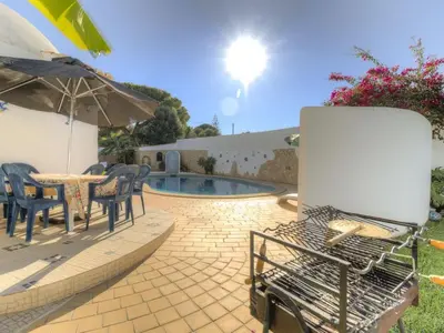 a patio with a table and chairs and an umbrella at Casa Vilamoura in Vilamoura