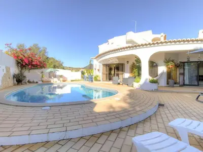 a courtyard with a swimming pool in front of a house at Casa Vilamoura in Vilamoura