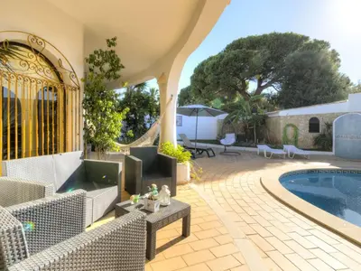 an outdoor patio with a swimming pool and a house at Casa Vilamoura in Vilamoura
