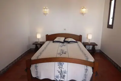 a bedroom with a bed with two lamps on two tables at Casa Nill - Apartamento na Praia do Forte de São João em Albufeira in Albufeira