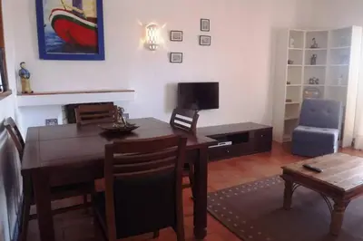 a living room with a dining room table and a television at Casa Nill - Apartamento na Praia do Forte de São João em Albufeira in Albufeira