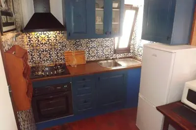 a kitchen with blue cabinets and a sink and a refrigerator at Casa Nill - Apartamento na Praia do Forte de São João em Albufeira in Albufeira