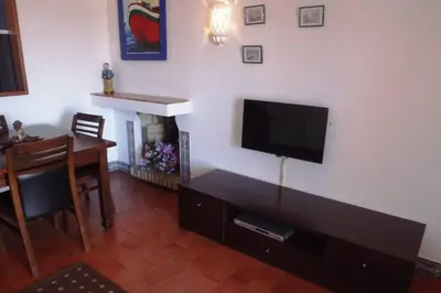 a living room with a flat screen tv and a table at Casa Nill - Apartamento na Praia do Forte de São João em Albufeira in Albufeira