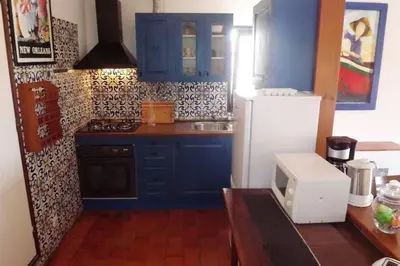 a kitchen with blue cabinets and a white refrigerator at Casa Nill - Apartamento na Praia do Forte de São João em Albufeira in Albufeira