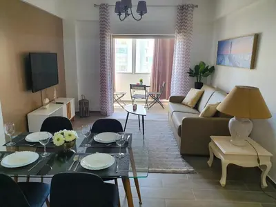 a living room with a couch and a table at Apartamento de Quarteira in Quarteira