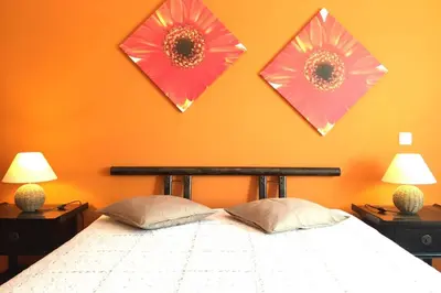 a bedroom with a bed with two flowers on the wall at Edificio Sao Joao das areias Strip l OURA in Albufeira