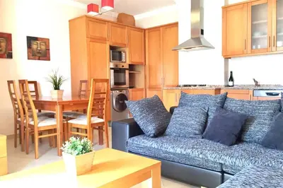 a living room with a couch and a table at Edificio Sao Joao das areias Strip l OURA in Albufeira