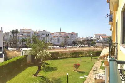 a balcony of a building with a green yard at Edificio Sao Joao das areias Strip l OURA in Albufeira