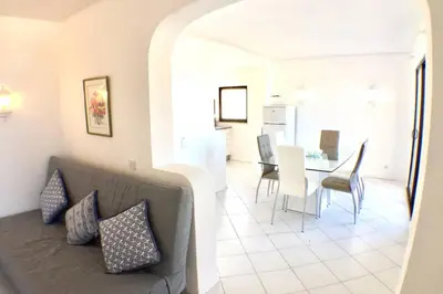 a living room and dining room with a couch and a table at Bellavista Avenida Pool and city center in Albufeira