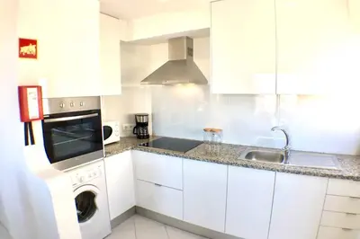 a white kitchen with a washing machine and a sink at Bellavista Avenida Pool and city center in Albufeira