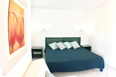 a bedroom with a blue bed with two pillows at Bellavista Avenida Pool and city center in Albufeira