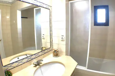 a bathroom with a sink and a mirror and a tub at Bellavista Avenida Pool and city center in Albufeira