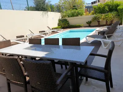 a table and chairs next to a swimming pool at Luxury Villa Corcovada Nicole with privat heated pool in Albufeira