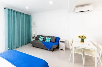 a living room with a couch and a table at Faro Downtown Ria Formosa Studios in Faro
