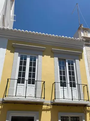 a yellow and white building with a balcony at Faro Downtown Ria Formosa Studios in Faro