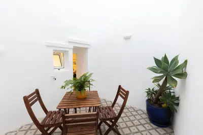a table and chairs with plants on a patio at Faro Downtown Ria Formosa Studios in Faro