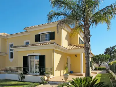 a house with a palm tree in front of it at Holiday Home Vila Sol by Interhome in Cabeço de Câmara