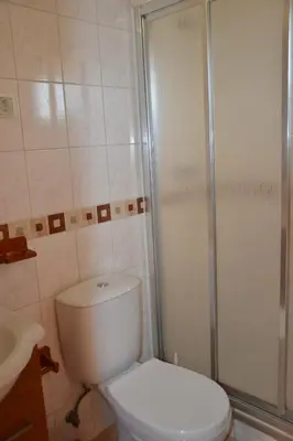 a bathroom with a white toilet and a shower at Villa Vacations House in Albufeira