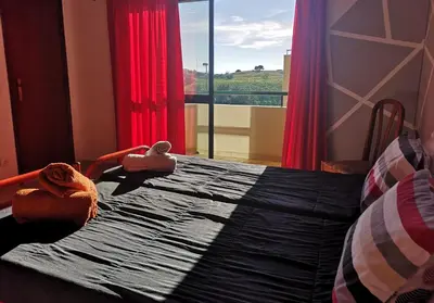 a bedroom with a bed and a window with red curtains at Villa Vacations House in Albufeira