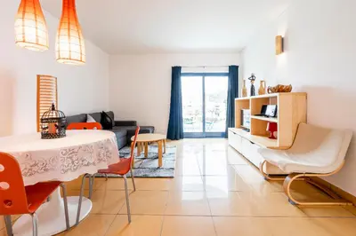 a living room with a table and chairs at Colorful Cozy Apartment view in Albufeira