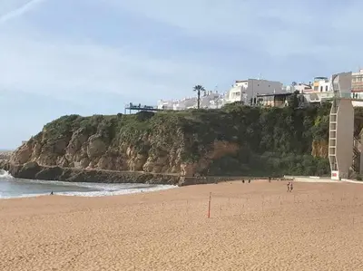 a group of people walking on a beach near the ocean at Albufeira Old Town Two bedroom Apartment Center in Albufeira