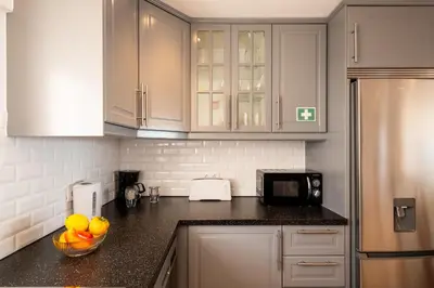 a kitchen with white cabinets and a bowl of fruit on the counter at #017 T2 Rossio by Home Holidays in Albufeira