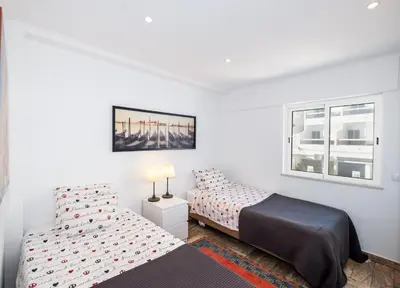a bedroom with two beds and a window at #017 T2 Rossio by Home Holidays in Albufeira