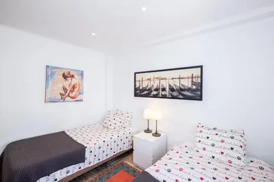 a bedroom with two beds and a bedside table at #017 T2 Rossio by Home Holidays in Albufeira