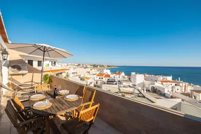 a table on a balcony with a view of the ocean at #017 T2 Rossio by Home Holidays in Albufeira