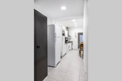 a kitchen with white appliances and a black door at REMODELED APARTMENT IN THE CITY CENTER. (FARO) in Faro