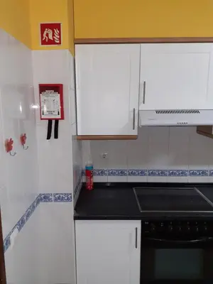 a kitchen with white cabinets and a black counter top at OCEAN VIEW Quartos in Faro