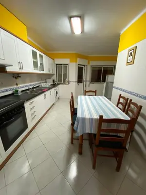 a kitchen with a table and chairs in it at OCEAN VIEW Quartos in Faro