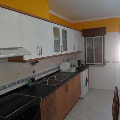 a kitchen with white cabinets and a sink at OCEAN VIEW Quartos in Faro