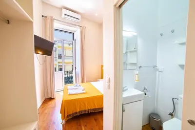 a small bathroom with a sink and a shower at Baron Faro - Guest House in Faro