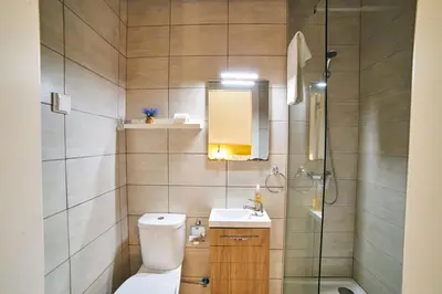 a bathroom with a toilet and a sink and a shower at Baron Faro - Guest House in Faro