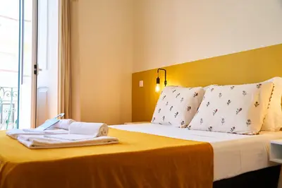 a hotel room with a bed with towels on it at Baron Faro - Guest House in Faro