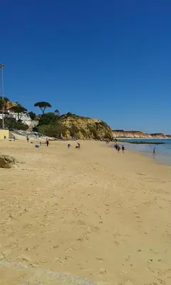 a group of people walking on a beach at O Pinheiro - Apartment Hannah in Olhos de Água