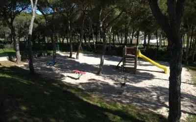 a playground with a slide in a park with trees at O Pinheiro - Apartment Hannah in Olhos de Água
