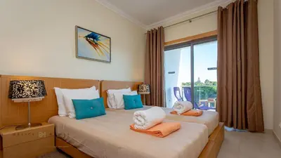 two beds in a hotel room with a window at Greice Homes-Apartamento 2 quartos, Monte da Balaia, Olhos de Água, Albufeira in Olhos de Água