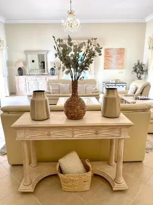 a living room with a table with a vase with flowers at Magellan House in Vilamoura