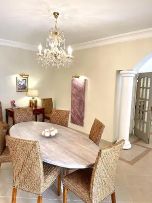 a dining room table with chairs and a chandelier at Magellan House in Vilamoura