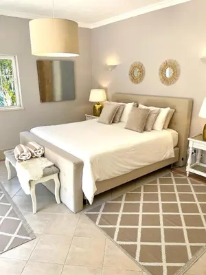 a bedroom with a large white bed and a chair at Magellan House in Vilamoura