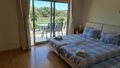 a bedroom with a bed and a balcony with a table at Monte da Eira apartments in Albufeira