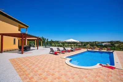 a swimming pool in a patio with lounge chairs at Villa Nincha - Heated Pool - Free wi-fi - Air Con in Albufeira