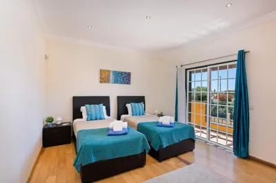 a bedroom with two beds and a large window at Villa Nincha - Heated Pool - Free wi-fi - Air Con in Albufeira