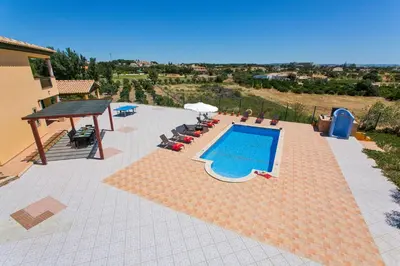 a swimming pool on a patio next to a house at Villa Nincha - Heated Pool - Free wi-fi - Air Con in Albufeira