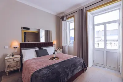 a bedroom with a large bed and a large window at Downtown Loulé in Loulé