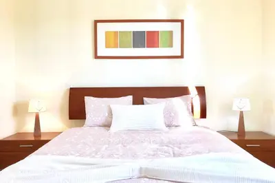 a bedroom with a large white bed with two lamps at Albufeira edificio Marina Inn Pateo in Albufeira