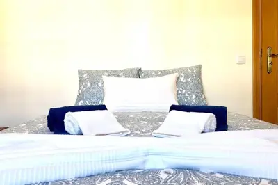 a bed with blue and white sheets and pillows at Albufeira edificio Marina Inn Pateo in Albufeira